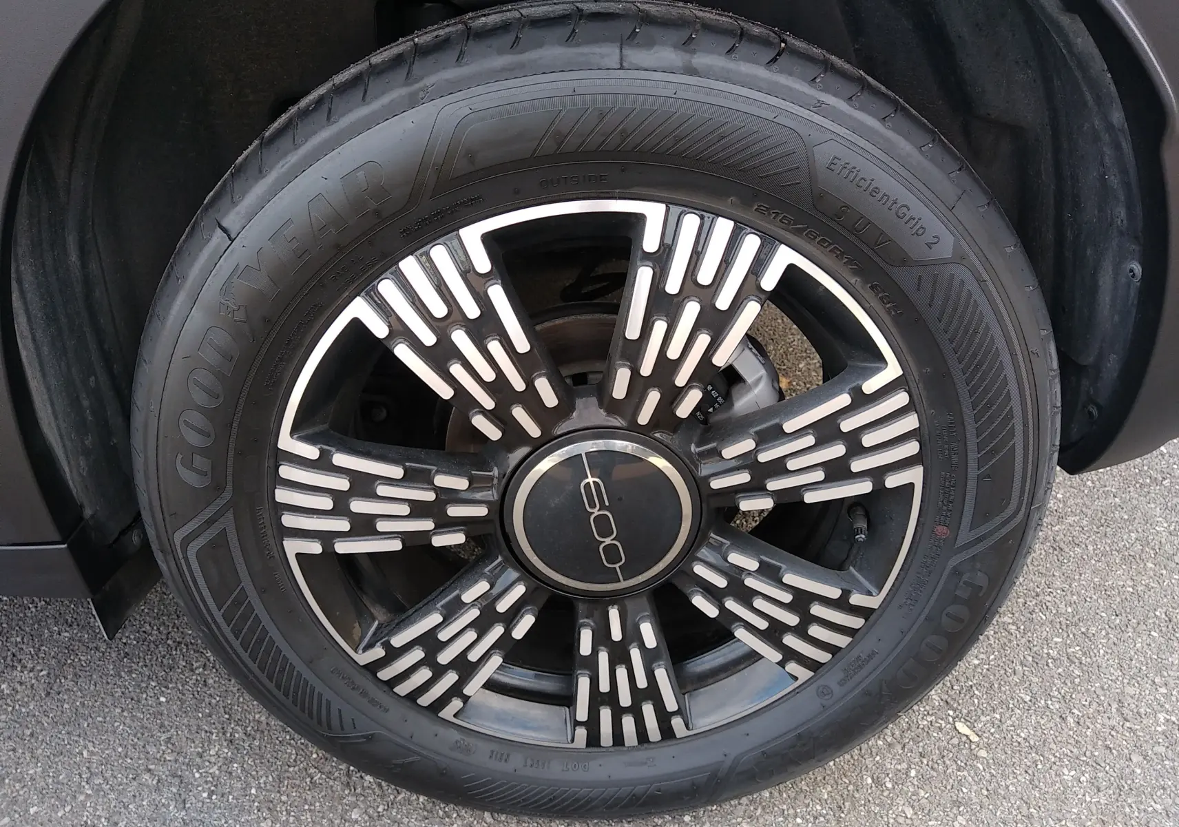 Gros plan sur la roue avant droite noire d'une FIAT 600 2025 avec jante stylisée et logo central "600".