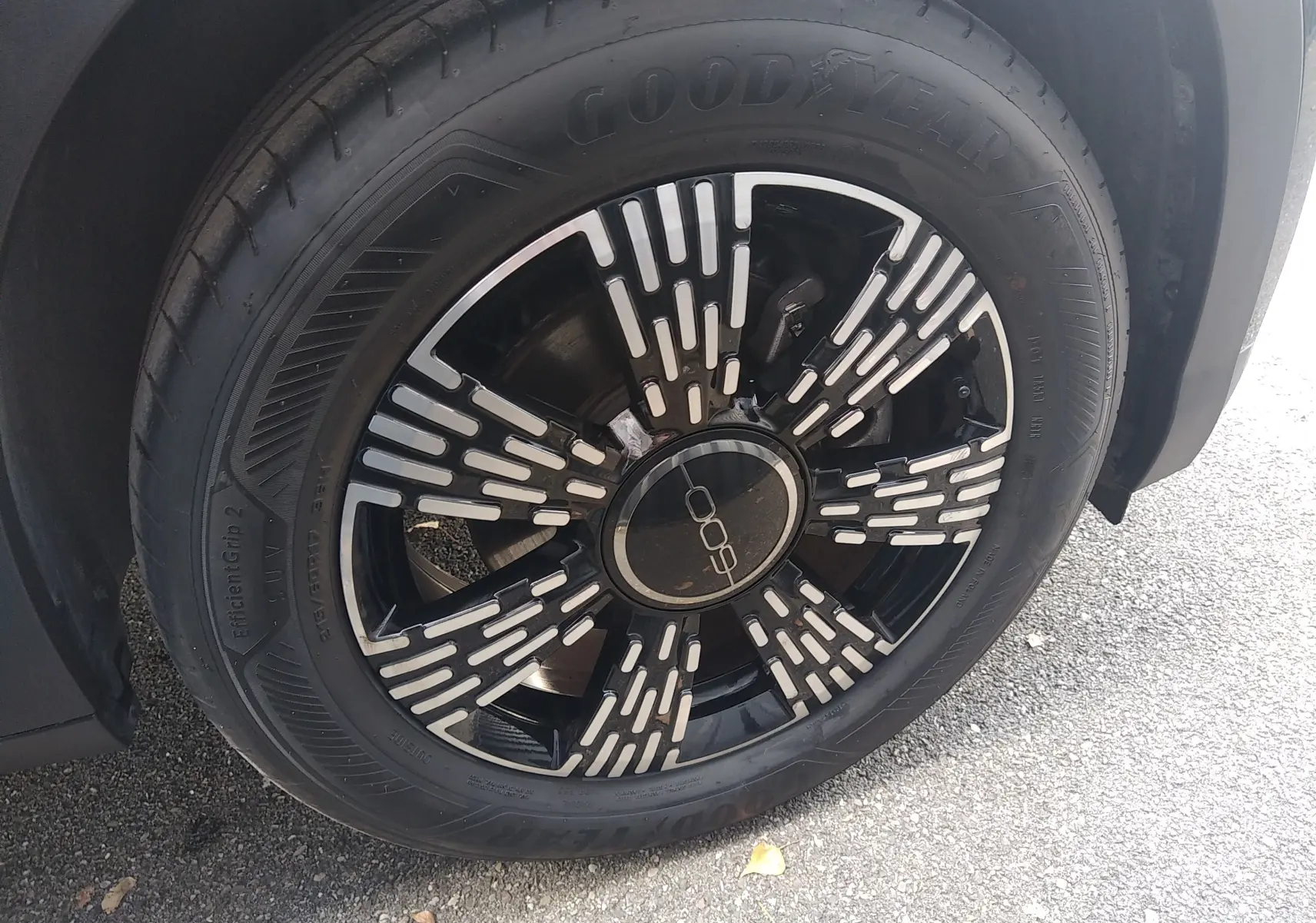 Gros plan sur la roue avant droite noire de la FIAT 600 2025 avec jante au design moderne et logo central distinctif.