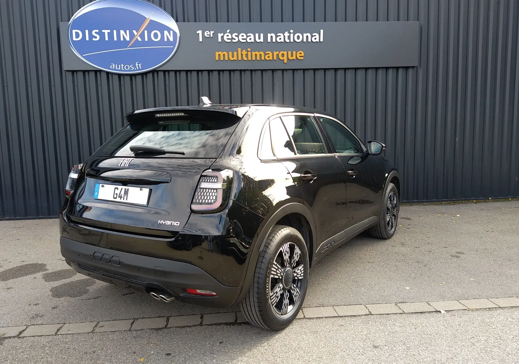 Vue 3/4 arrière droite d'une FIAT 600 noire hybride 2025, avec feux arrière LED et jantes stylisées noires.