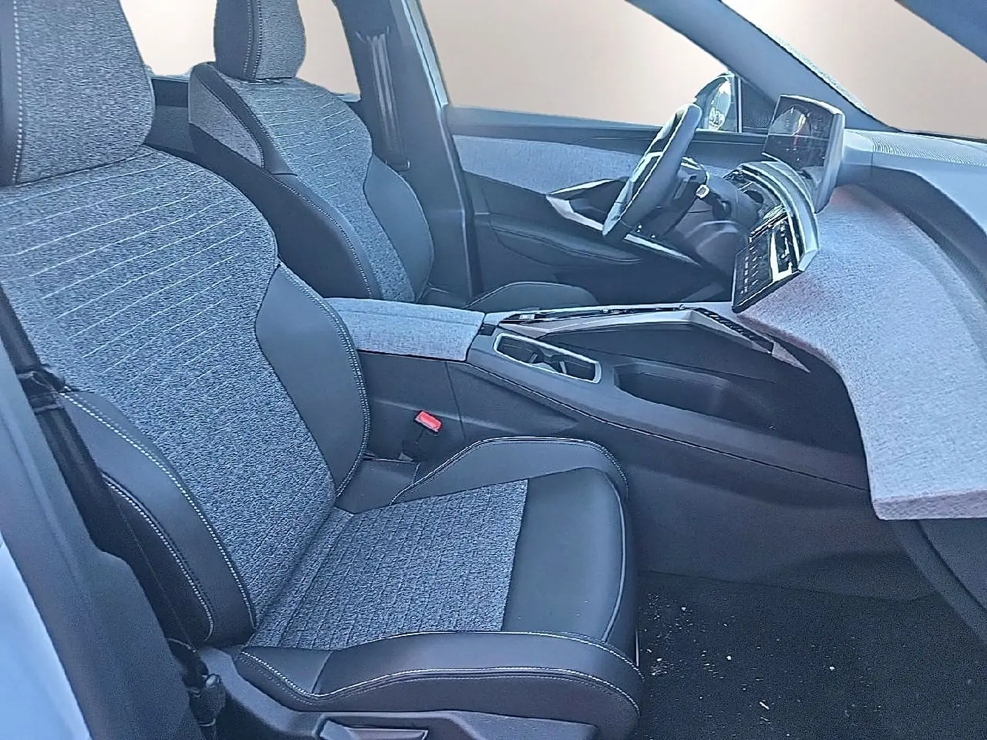 Vue intérieure côté conducteur du Peugeot 5008 Hybrid 145 allure e-dcs6 2025 avec sièges tissu gris et cuir noir.