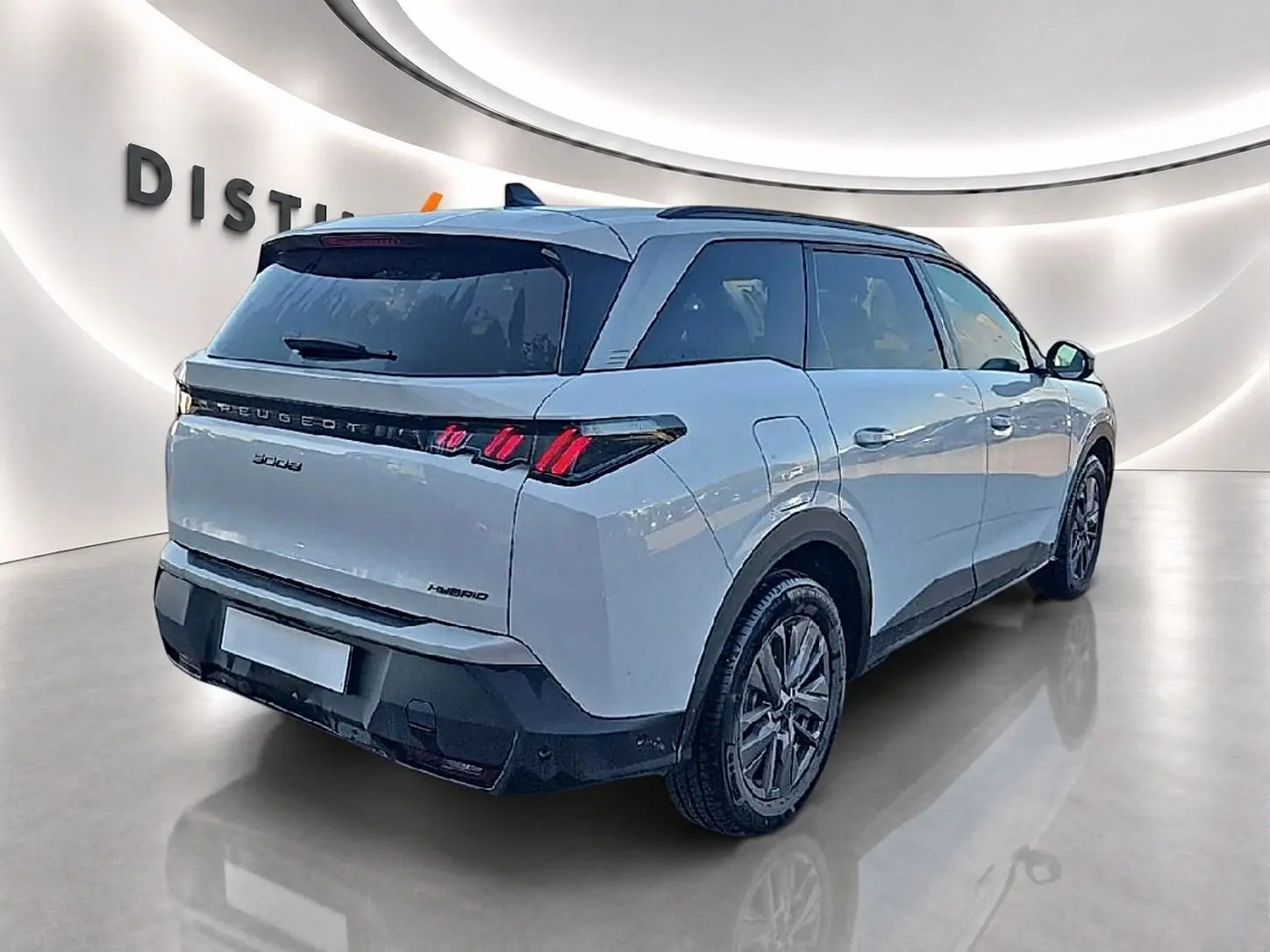 Vue 3/4 arrière droite d'un Peugeot 5008 blanc avec feux arrière LED et toit noir dans un showroom.