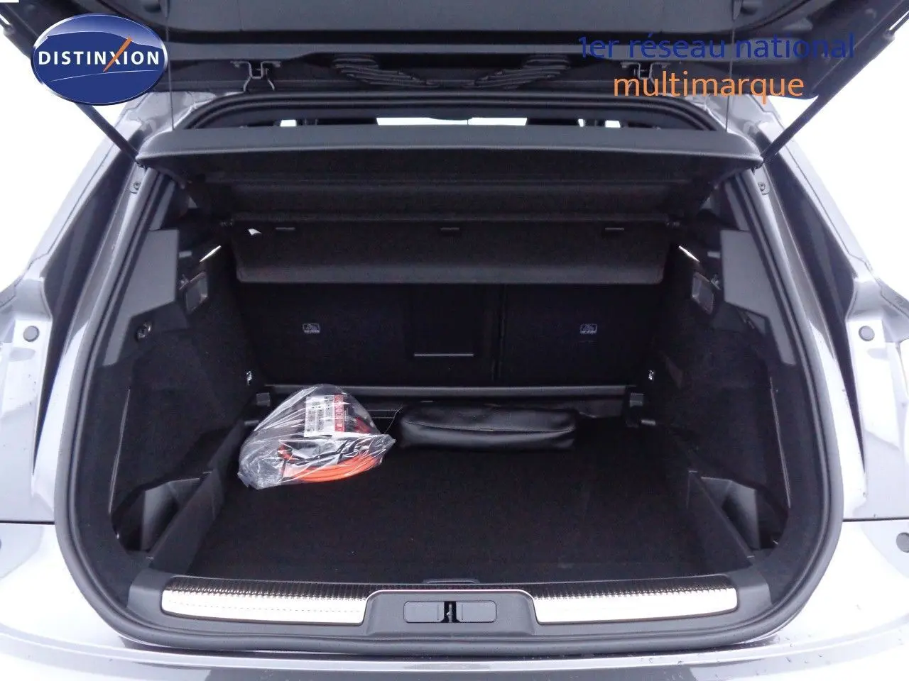 Coffre ouvert d'un DS7 Crossback gris platinium métal, montrant un espace de chargement propre avec accessoires rangés.