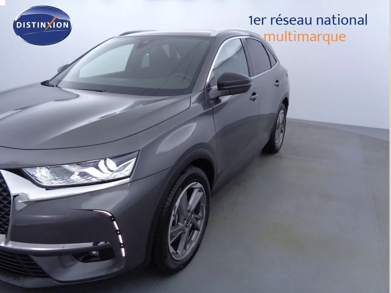 DS7 Crossback E-TENSE gris platinium métal en 3/4 avant droit, avec phares LED allumés et jantes alliage visibles.