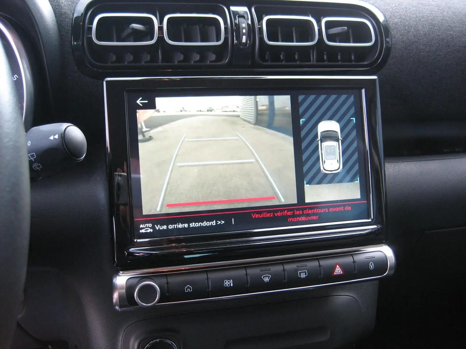 Vue rapprochée de l'écran tactile central du Citroën C3 Aircross gris 2022 affichant la caméra de recul et les commandes climatisation.