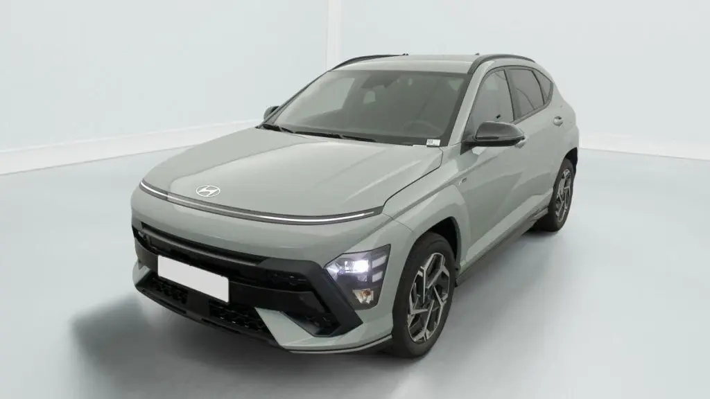 Hyundai Kona Hybrid 2025 Mirage Green en 3/4 avant droit, avec phares LED allumés et jantes N Line distinctives.