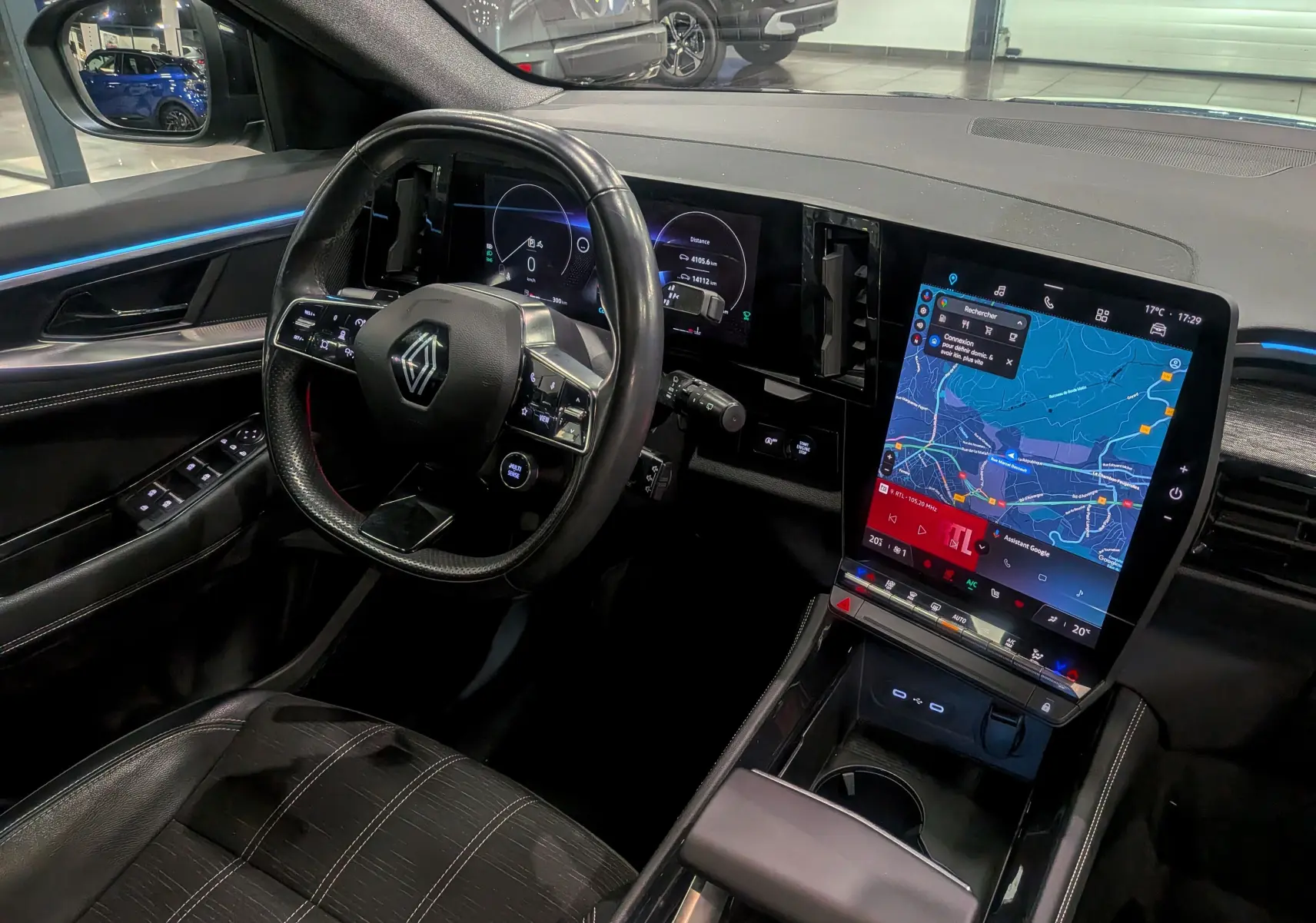 Intérieur du Renault Austral 2024, vue côté conducteur, volant multifonction et grand écran tactile vertical avec navigation.