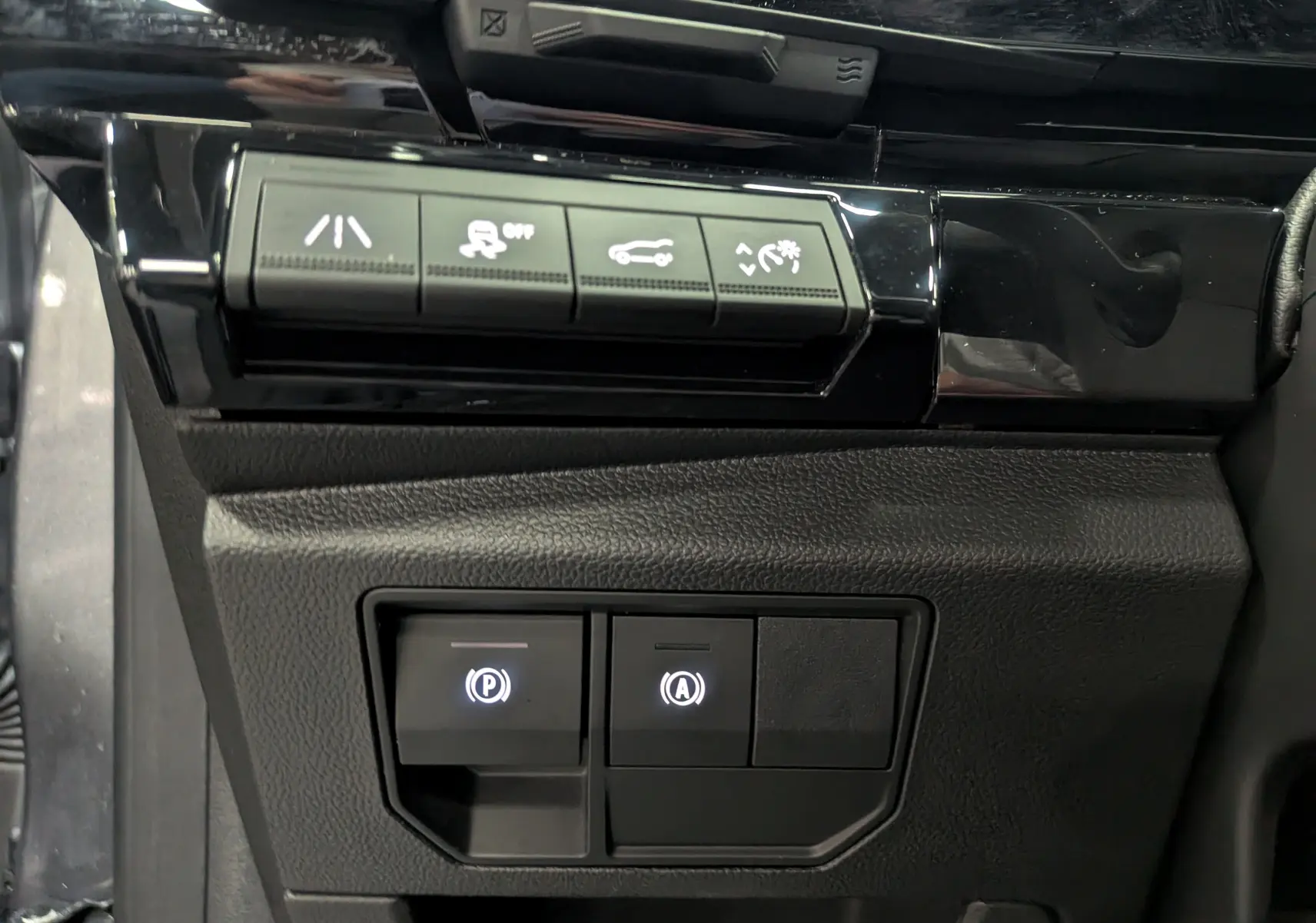 Panneau de commandes avec boutons d'assistance et frein à main électronique dans l'habitacle du Renault Austral 2024.