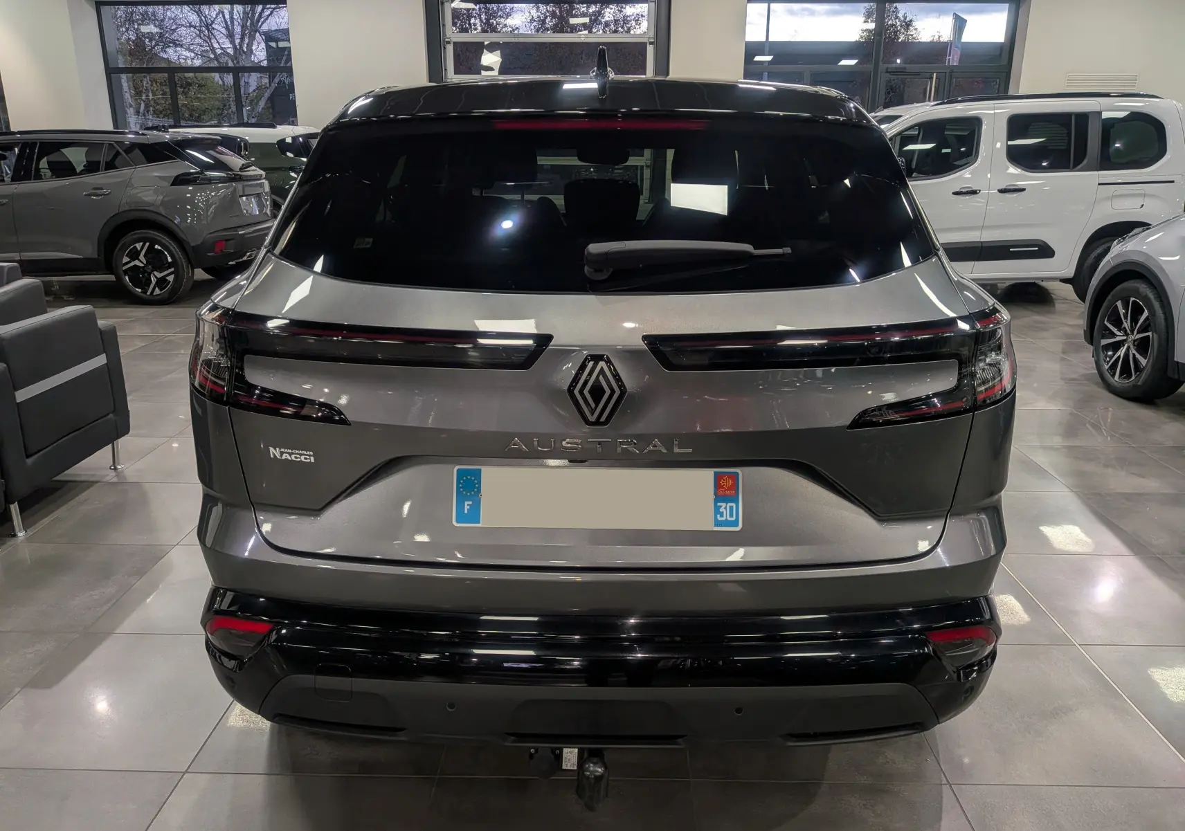 Vue arrière d'un Renault Austral gris schiste avec toit noir, mettant en valeur ses feux LED horizontaux et son logo central.