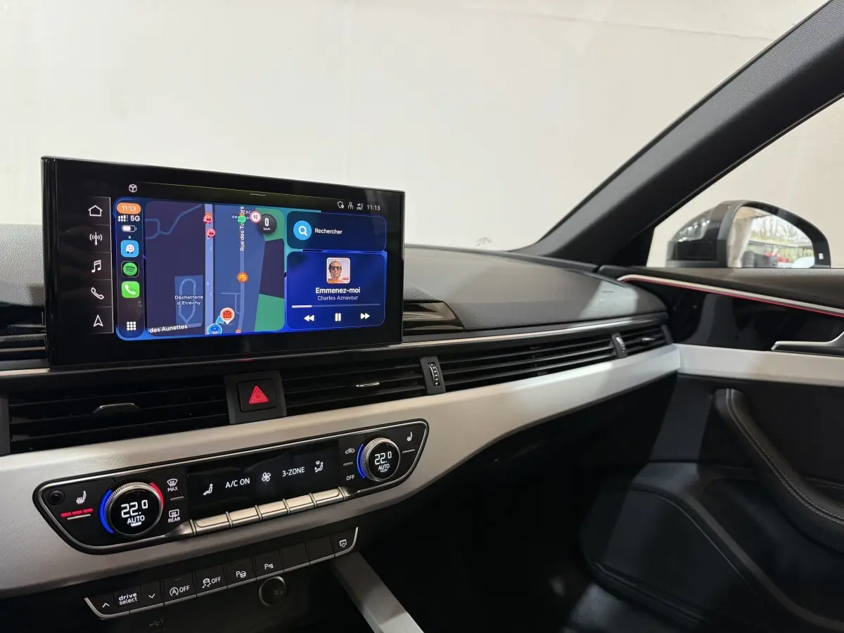 Vue intérieure côté passager de l'Audi A4 gris foncé 35 TFSI 2022, avec écran tactile et tableau de bord moderne.