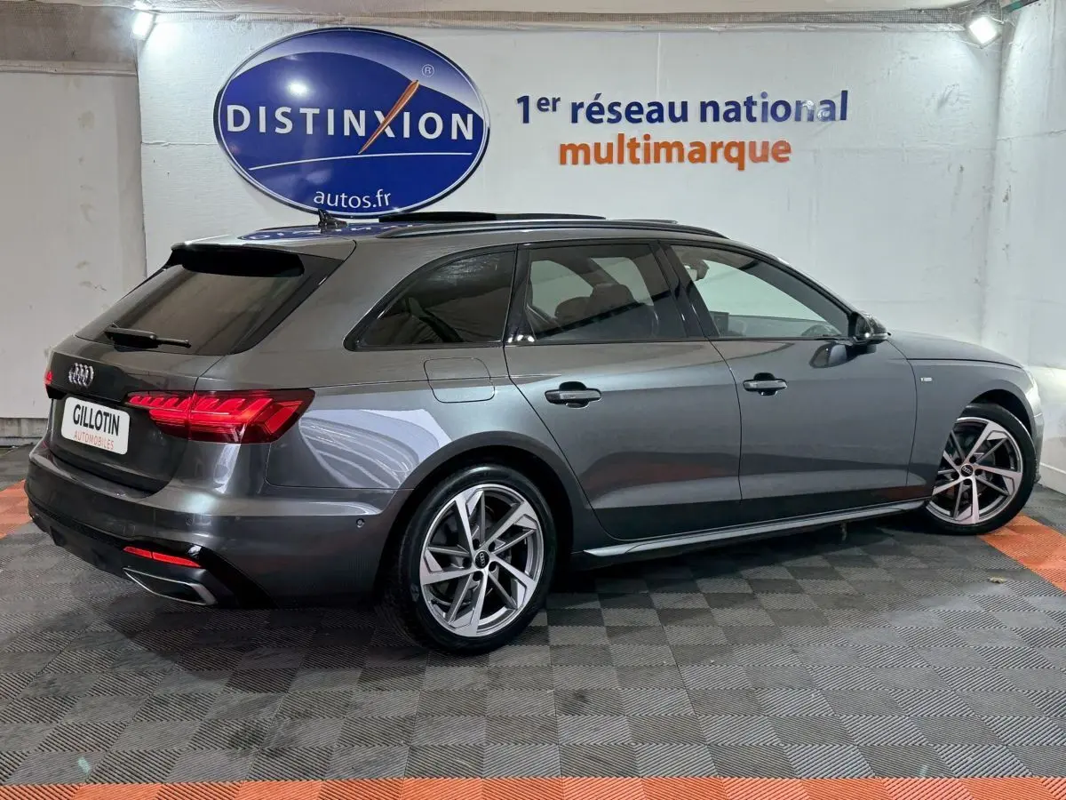 Audi A4 35 TFSI S Edition gris foncé vue 3/4 arrière droit en intérieur avec jantes alliage et vitres teintées.
