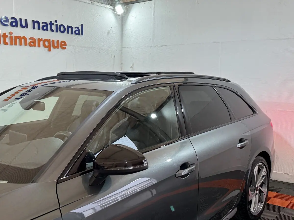 Vue côté gauche d'un Audi A4 35 TFSI S Edition gris foncé avec toit ouvrant et jantes alliage visibles.