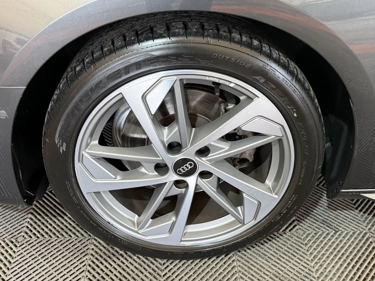 Gros plan sur la roue avant droite gris foncé d’une Audi A4 35 TFSI S Edition avec jante en alliage moderne.