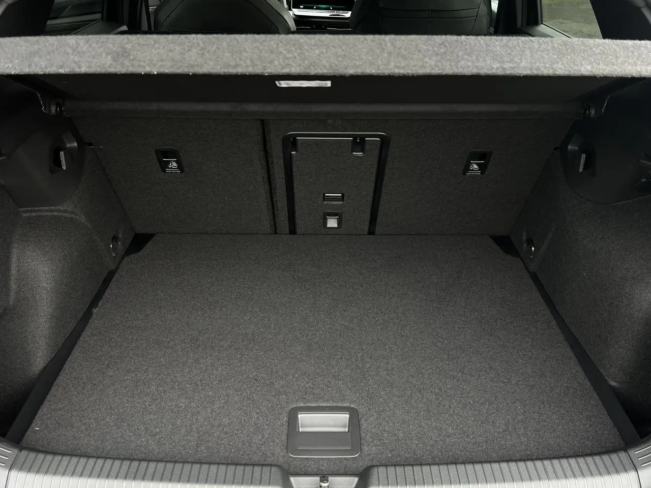 Vue intérieure du coffre spacieux et tapissé de la Volkswagen Golf VIII 2.0 TDI noire, sans chargement visible.