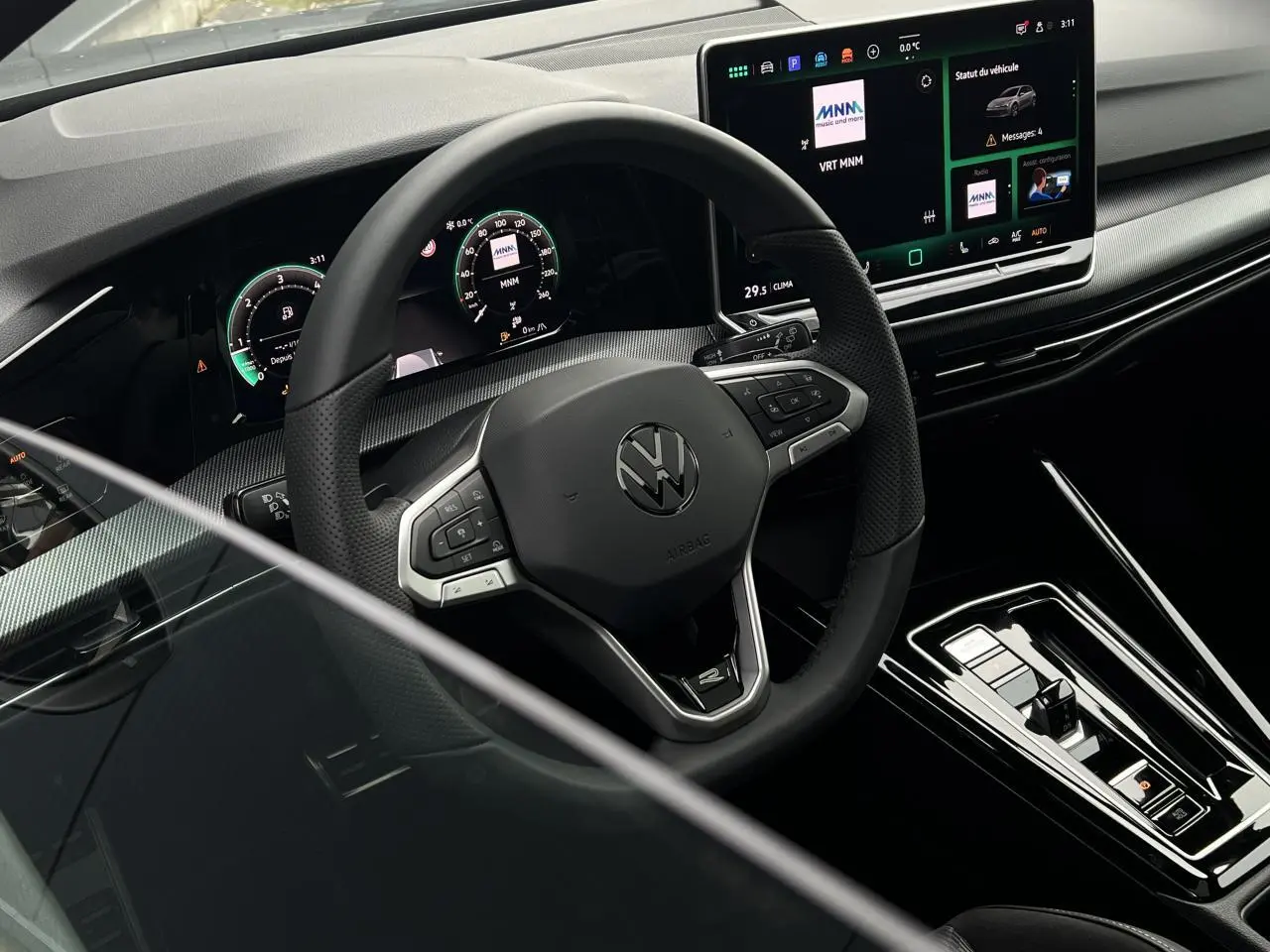 Vue intérieure centrée sur le volant sport Volkswagen Golf VIII noir avec tableau de bord digital et écran tactile.