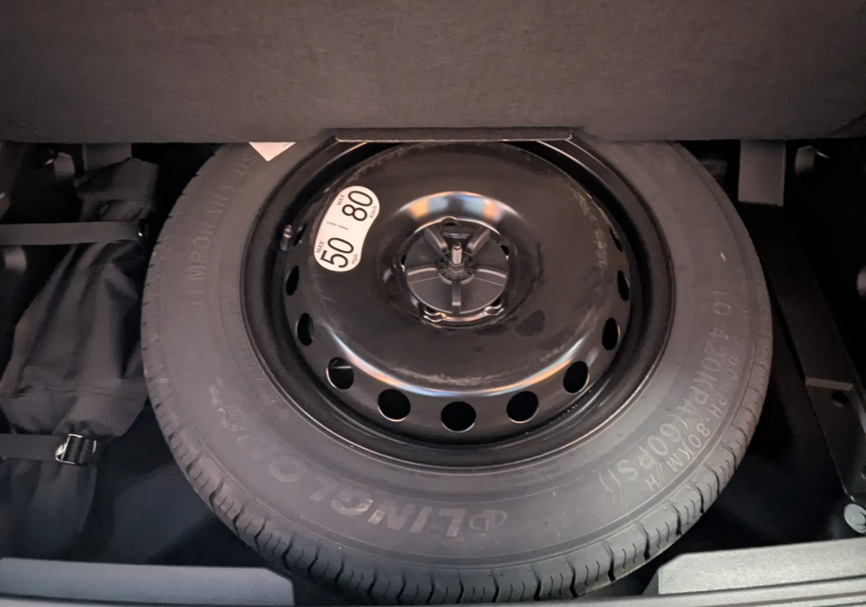 Gros plan sur la roue de secours temporaire noire dans le coffre du Renault Austral gris schiste 2025.