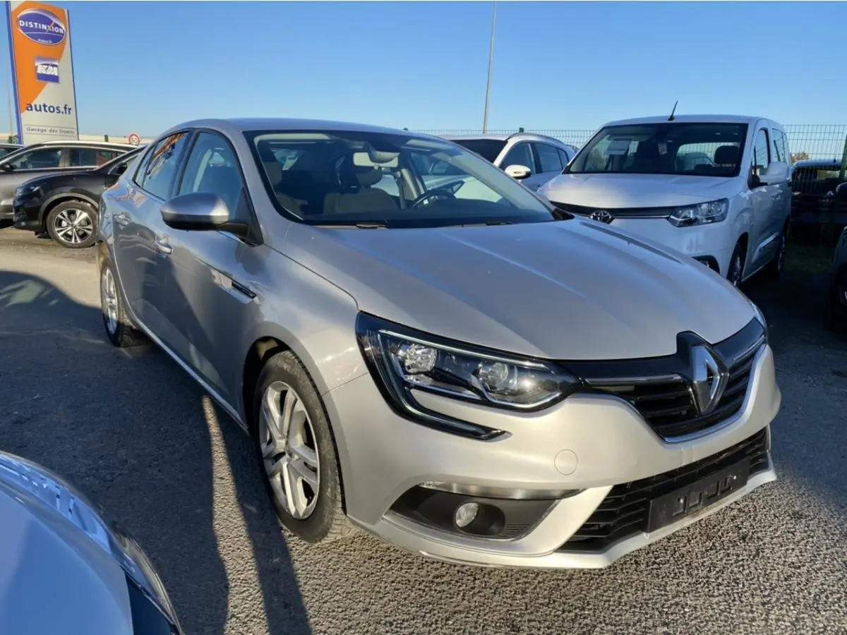 Renault Mégane gris platine vue 3/4 avant droit avec projecteurs antibrouillard et calandre noire.