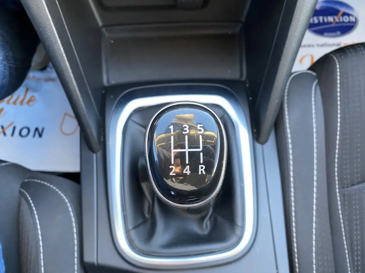 Le levier de vitesses manuel noir de la Renault Mégane gris platine, vu en gros plan depuis le dessus.
