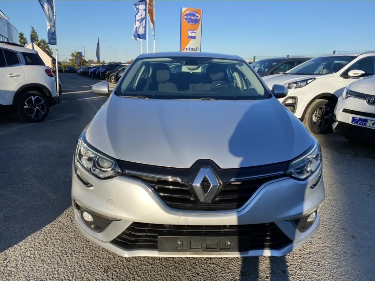 Vue avant d'une Renault Mégane Sedan gris platine 2017 avec projecteurs antibrouillard et calandre noire brillante.