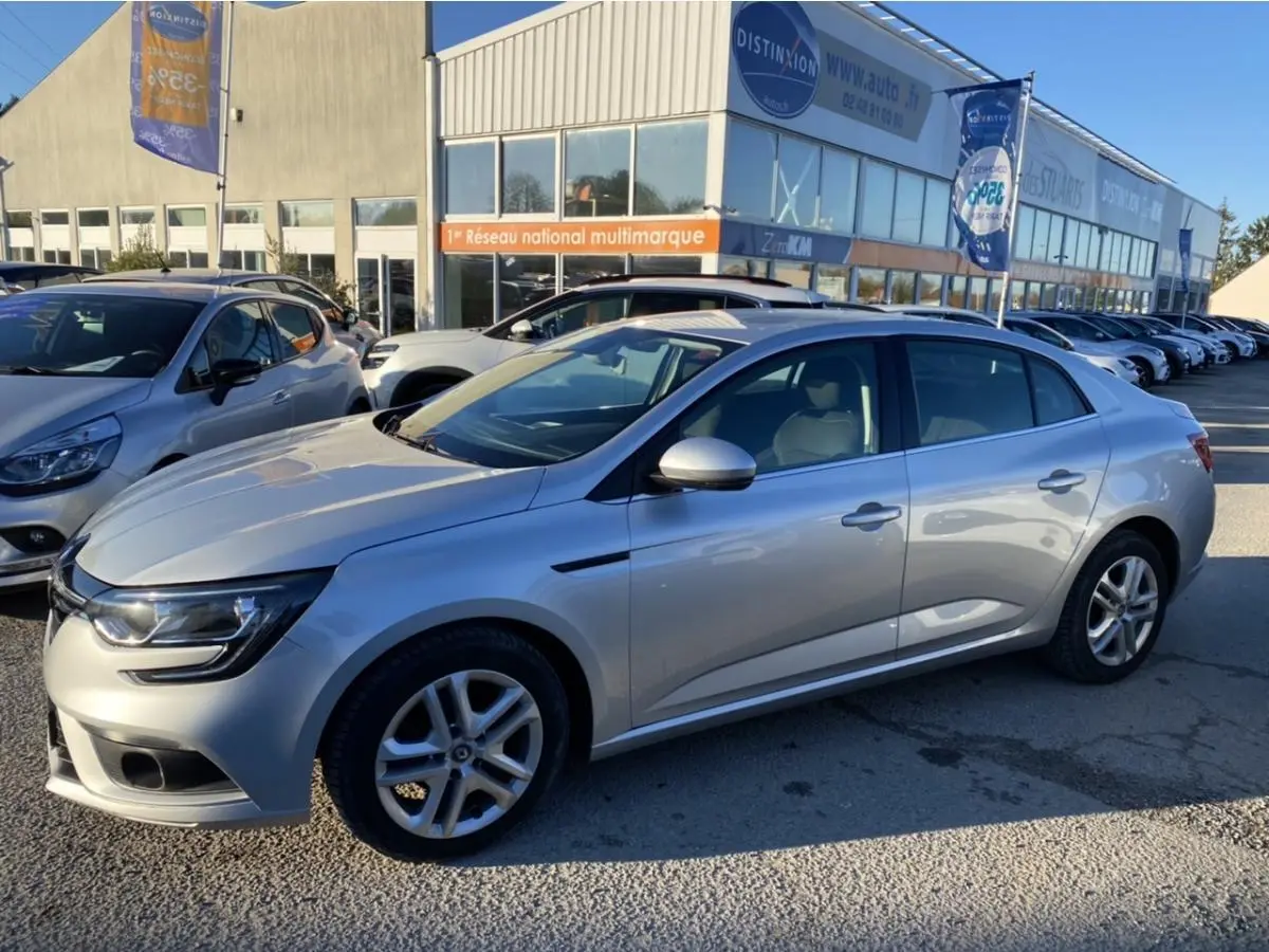 Renault Mégane Sedan gris platine vue de profil côté gauche, avec jantes alliage et projecteurs antibrouillard avant.