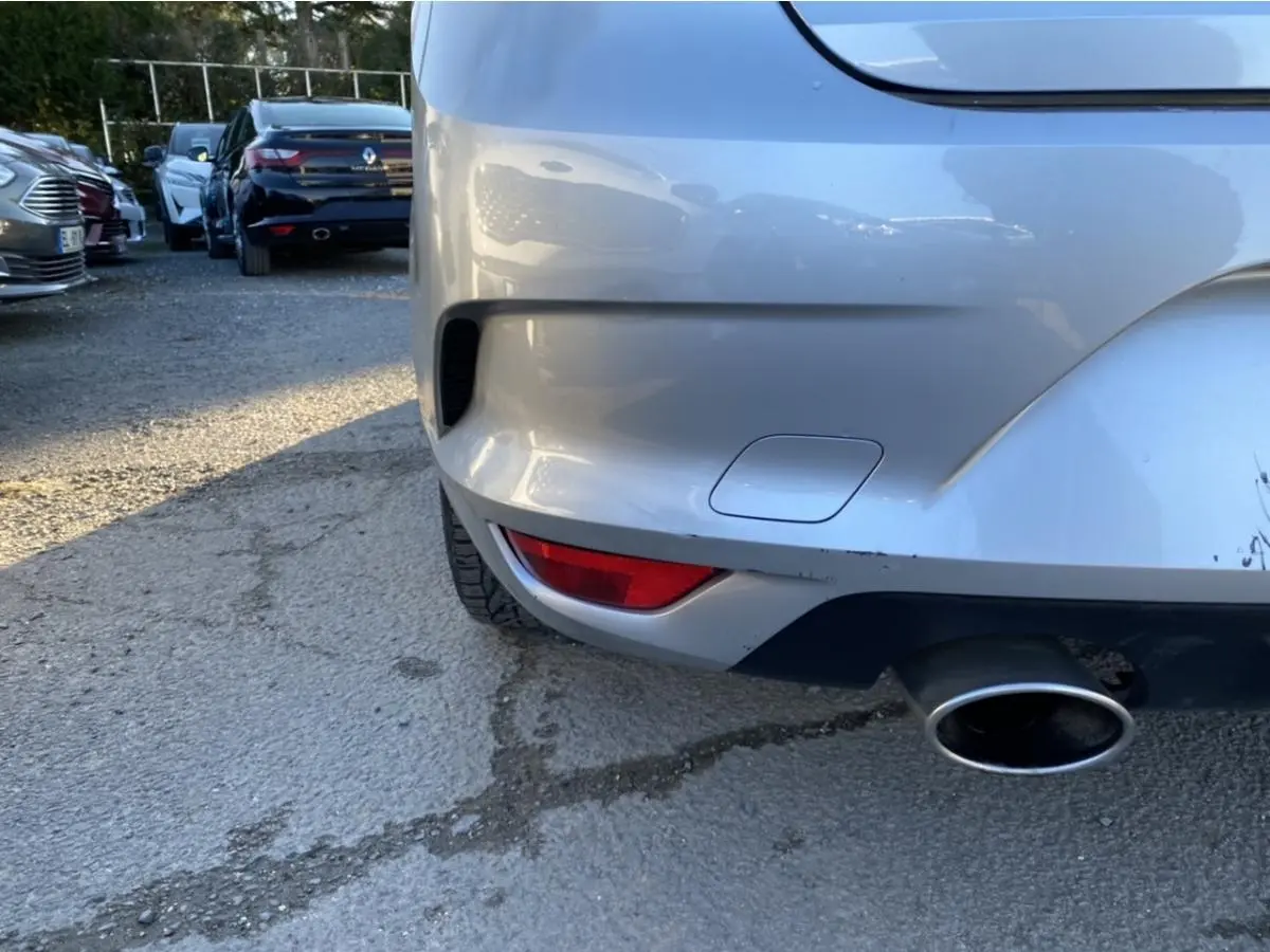 Détail du pare-chocs arrière droit gris platine de la Renault Mégane Sedan 2017 avec sortie d’échappement visible.