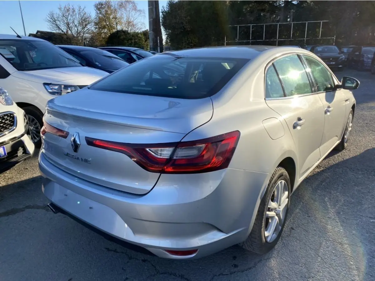 Renault Mégane Sedan gris platine vue 3/4 arrière droit, avec feux arrière allongés et jantes alliage.