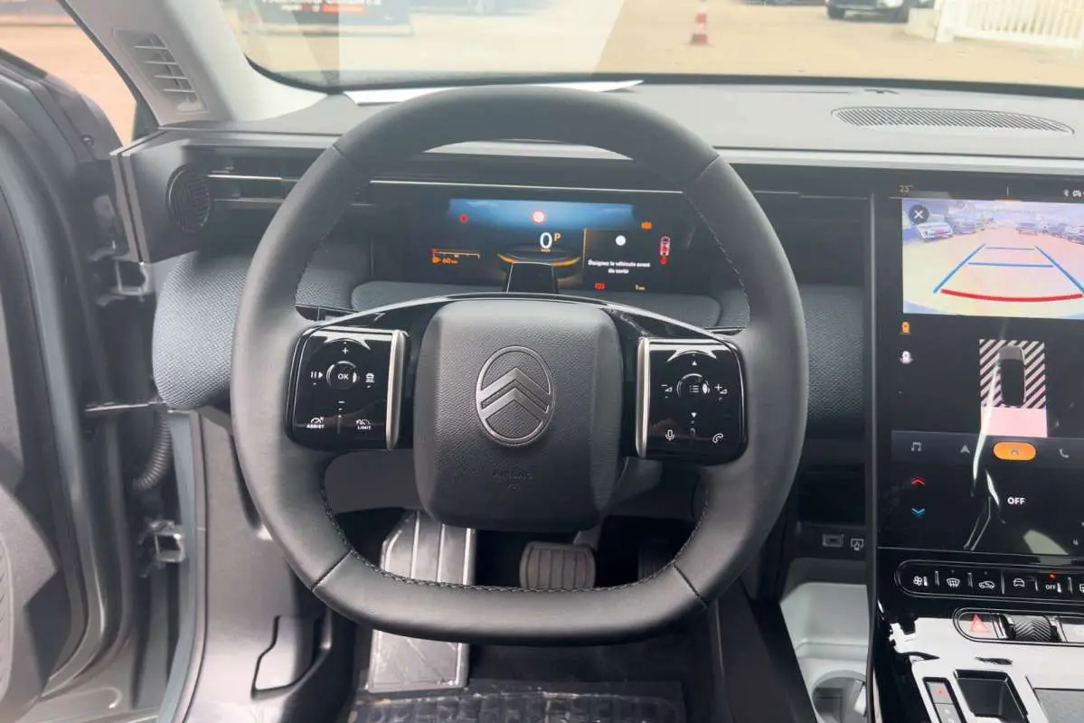 Vue intérieure centrée sur le volant cuir multifonctions du Citroën C5 Aircross Hybrid 145 Plus PK Drive 2026.