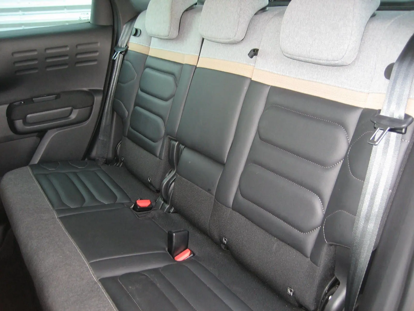 Vue latérale des sièges arrière en cuir noir et tissu gris clair du Citroën C3 Aircross II 2022 finition Shine Pack.