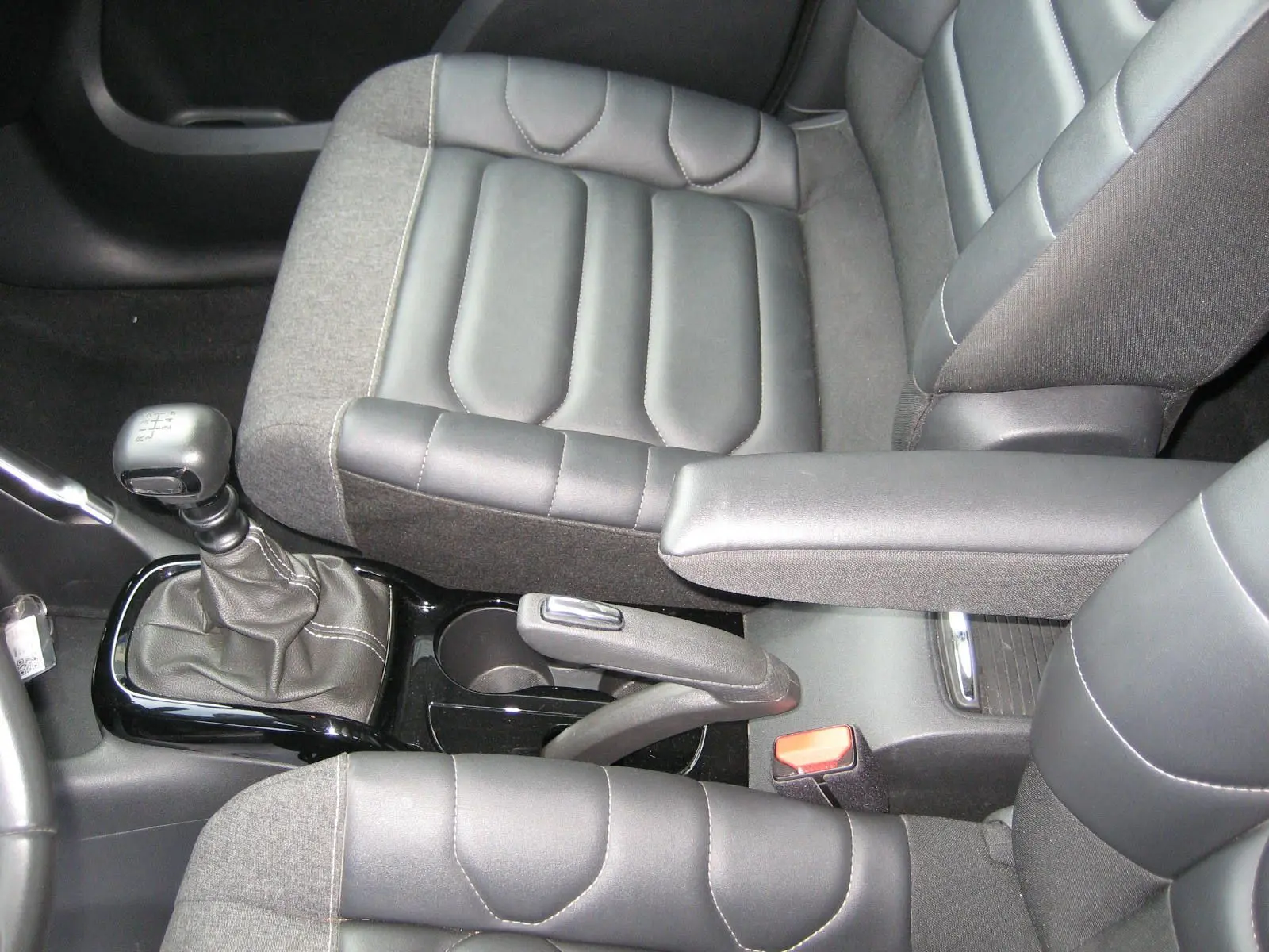 Vue rapprochée de l'intérieur du Citroën C3 Aircross 2022 montrant les sièges bi-matière gris et le levier de vitesse manuel.