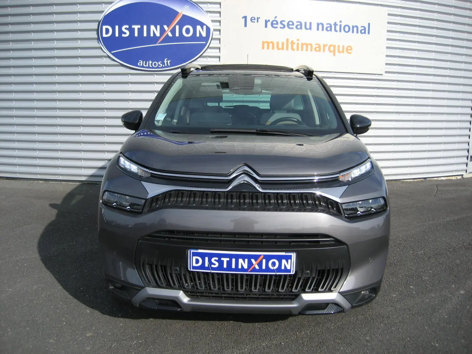 Vue frontale d'un Citroën C3 Aircross gris platinium avec calandre noire et phares LED fins.