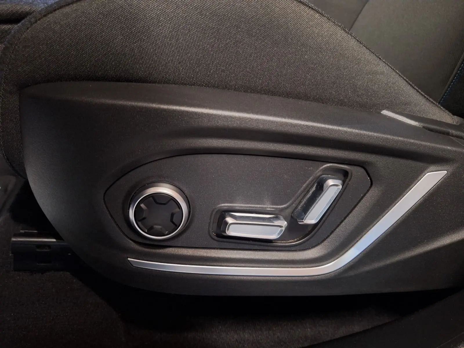 Gros plan sur les commandes électriques de réglage du siège côté gauche d'un LYNK & CO 01 noir, version 2023.