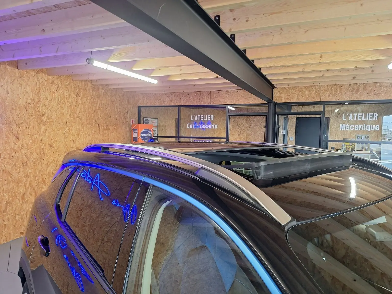 Vue rapprochée du toit ouvrant et des barres de toit argentées sur le côté gauche d'un LYNK & CO 01 noir.