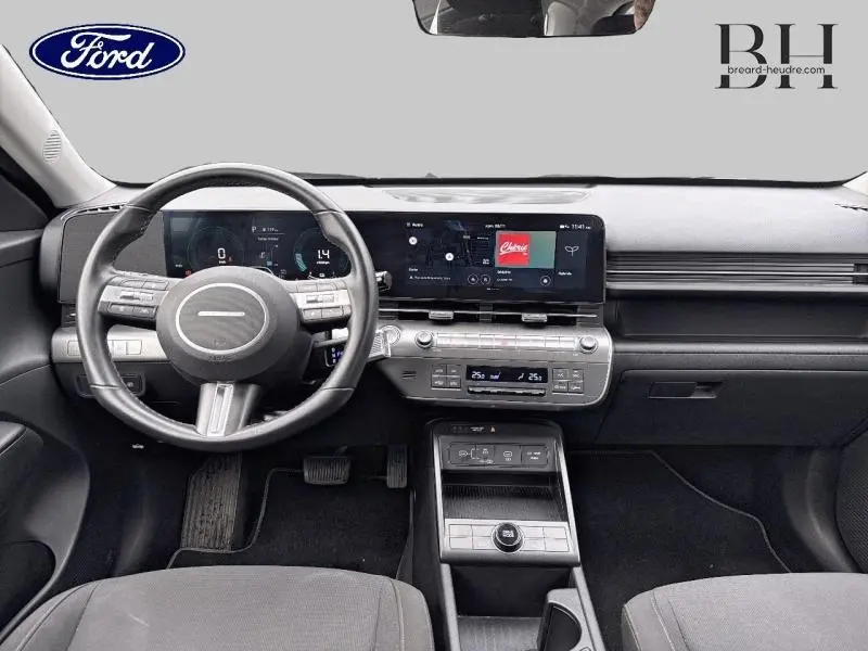 Vue intérieure avant du tableau de bord et volant cuir multifonction d'une Hyundai Kona 2023 Denim Blue perlé métallisé.