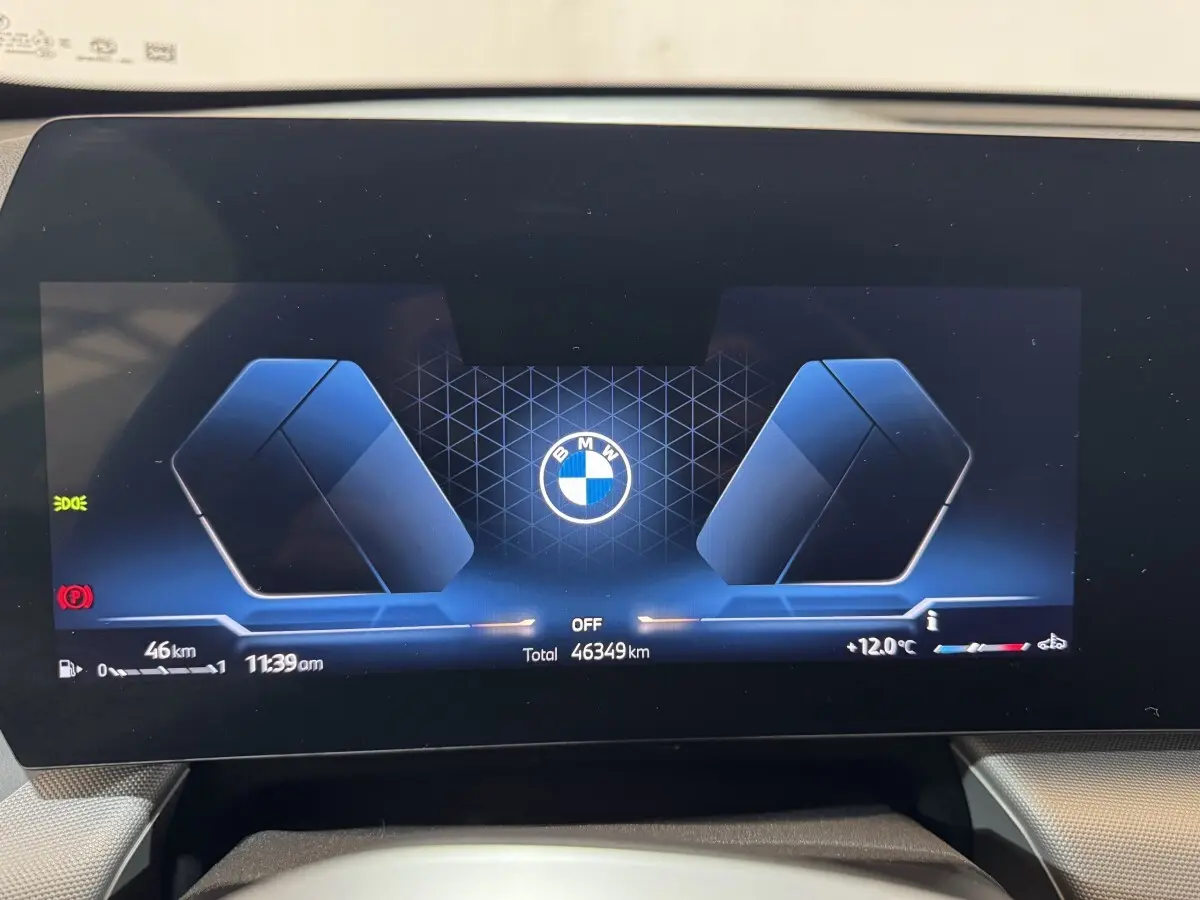 Affichage digital du combiné d'instruments BMW X1 2024, vue frontale avec logo central et informations numériques.