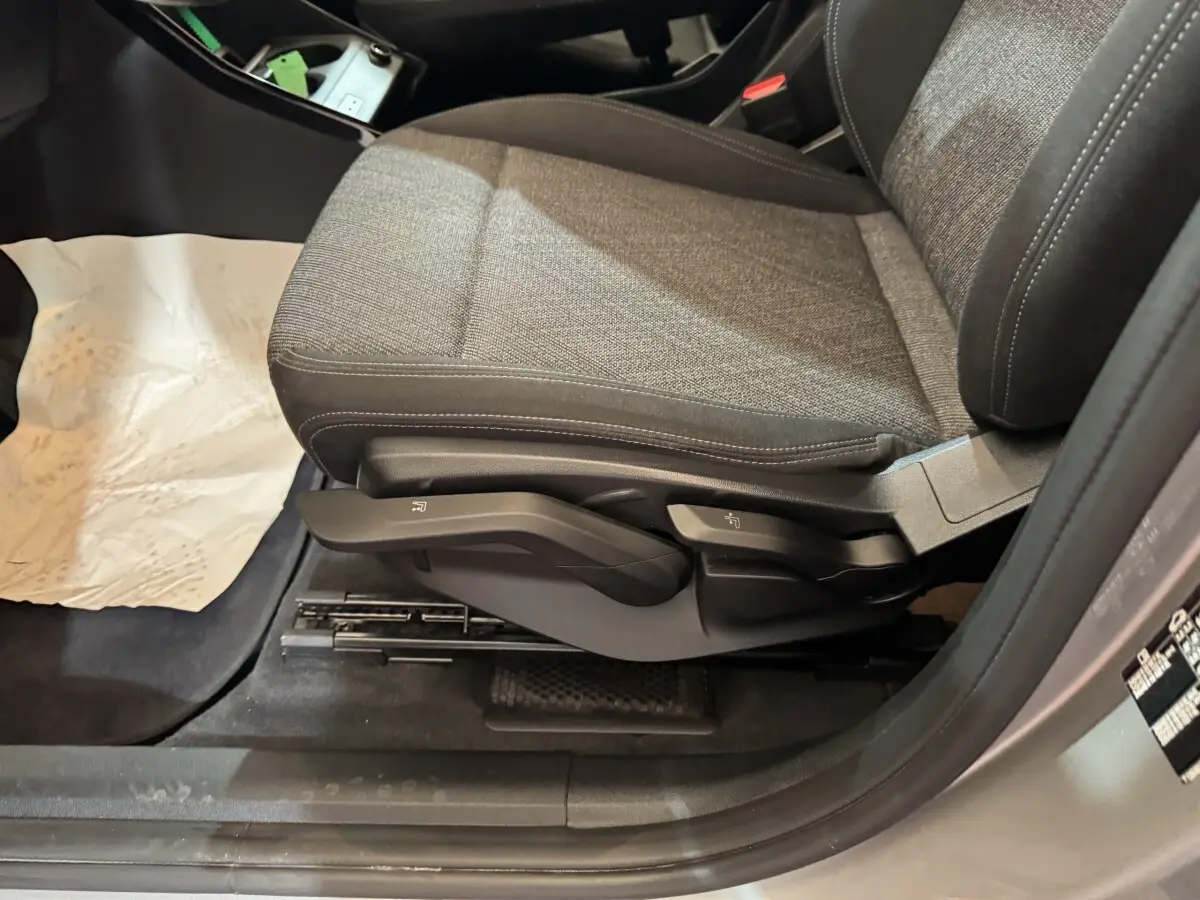 Vue rapprochée du siège avant droit gris tissu de la BMW X1 sDrive20i Business Design 2024, avec commandes manuelles visibles.