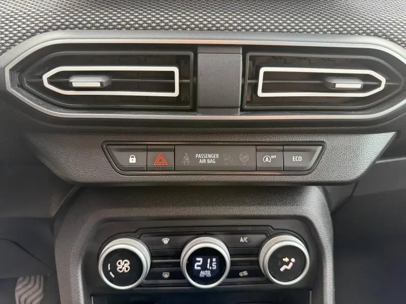 Détail du tableau de bord du Dacia Jogger 2025 montrant les aérateurs horizontaux et les commandes de climatisation numériques.