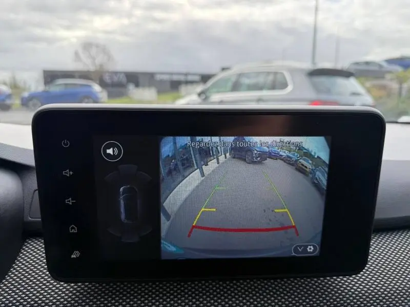 Écran de caméra de recul dans un Dacia Jogger gris schiste, vue arrière avec guidage de trajectoire coloré.