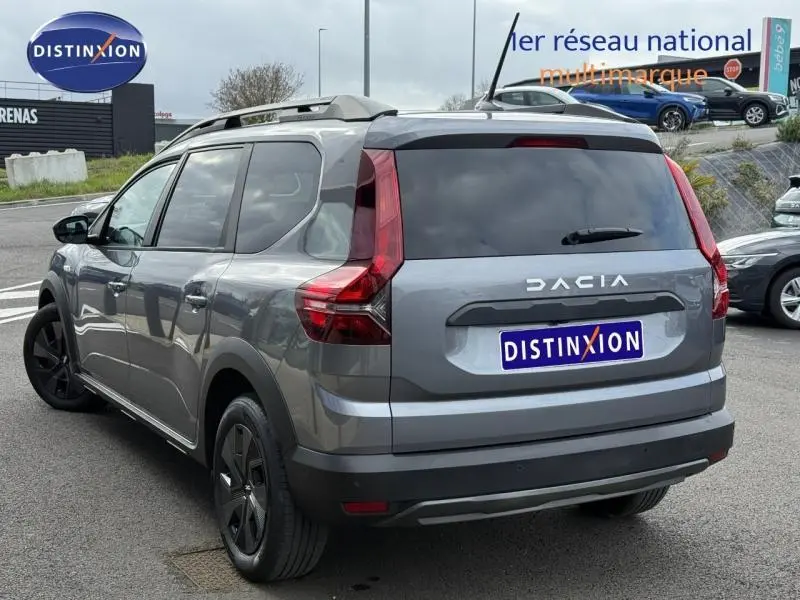 Vue 3/4 arrière droite d'un Dacia Jogger gris schiste métallisé avec feux arrière verticaux et toit surélevé.