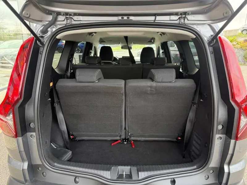 Vue arrière du coffre ouvert du Dacia Jogger gris schiste métallisé, montrant les sièges arrière en position verticale.