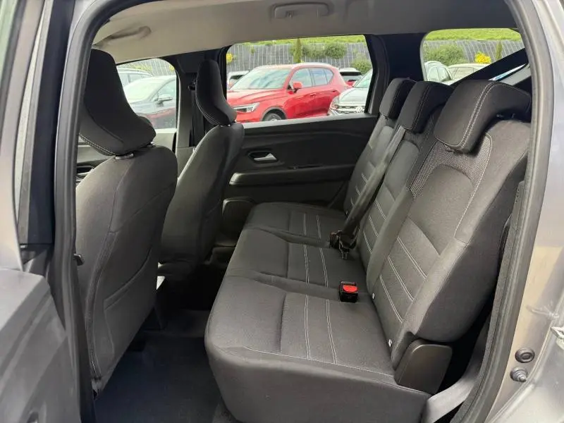 Vue intérieure côté gauche montrant la banquette arrière en tissu noir du Dacia Jogger Gris Schiste métallisé 2025 7 places.