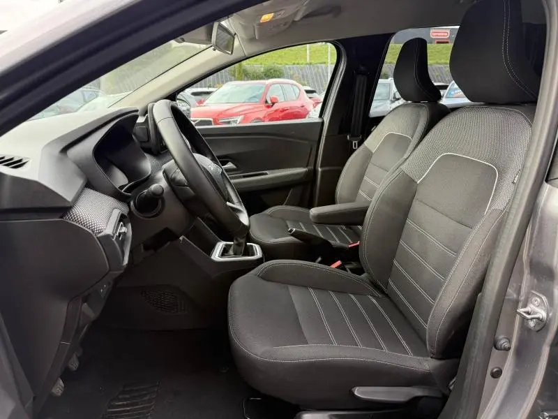 Vue intérieure côté conducteur du Dacia Jogger 2025 gris Schiste, montrant les sièges avant et le volant.