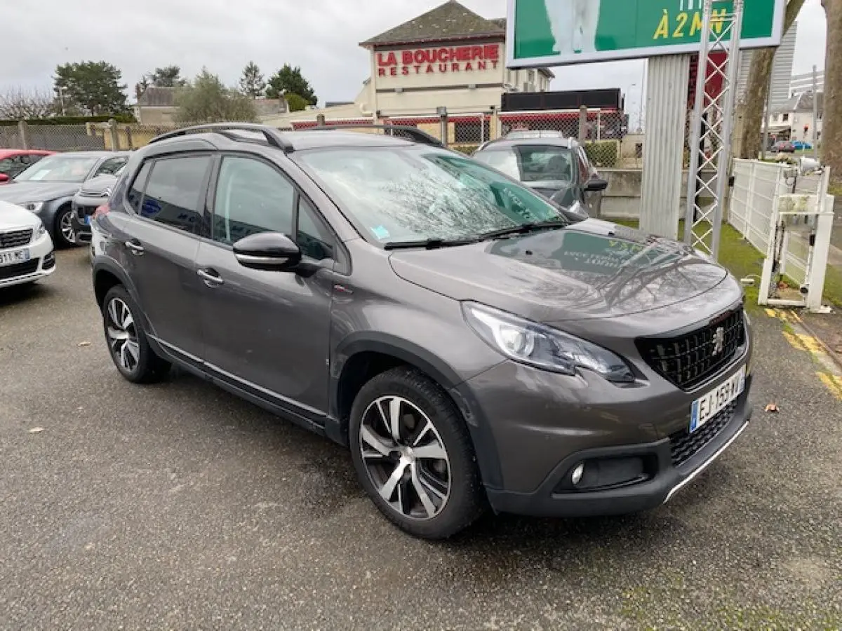 Peugeot 2008 gris platinium en 3/4 avant droit, avec jantes alliage noires diamantées et barres de toit noir brillant.