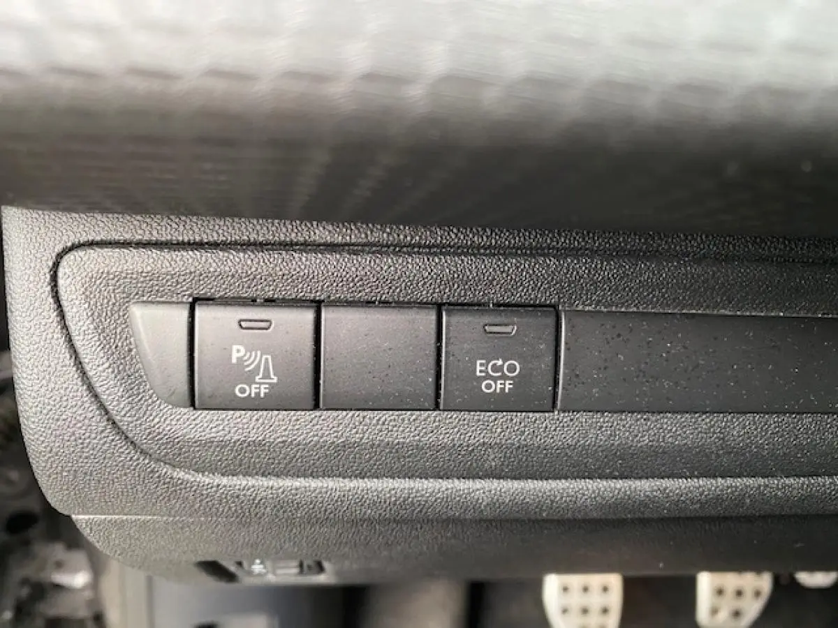 Gros plan sur les boutons de commande du tableau de bord du Peugeot 2008 GT Line 2017, avec fonction ECO et aide au stationnement désactivées.