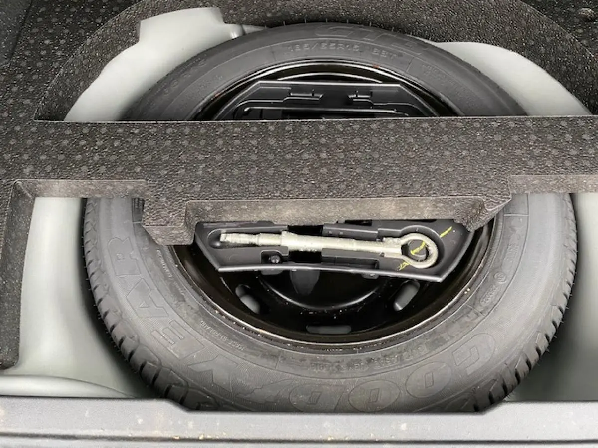 Gros plan sur la roue de secours tôle 15 pouces du coffre d'une Peugeot 2008 GT Line gris platinium de 2017.