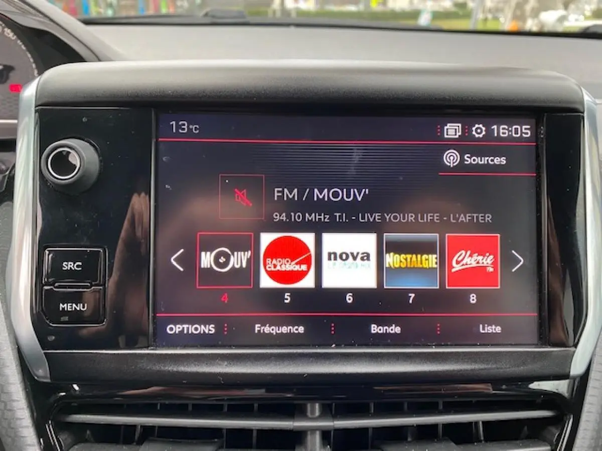 Écran tactile central de la Peugeot 2008 GT Line 2017 affichant les stations radio, avec commandes autour et tableau de bord partiel.