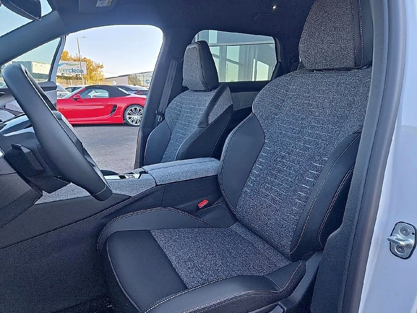 Vue intérieure côté conducteur du Peugeot 5008 Hybrid 145 allure e-dcs6 2025, sièges tissu gris et cuir noir.