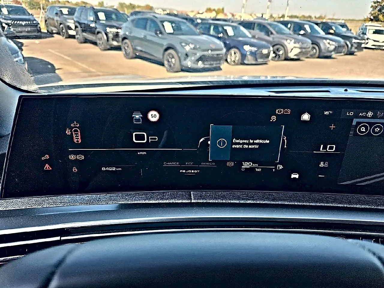Vue intérieure du tableau de bord numérique du Peugeot 5008 Hybrid 145 allure e-dcs6, affichage multifonction et alertes visibles.