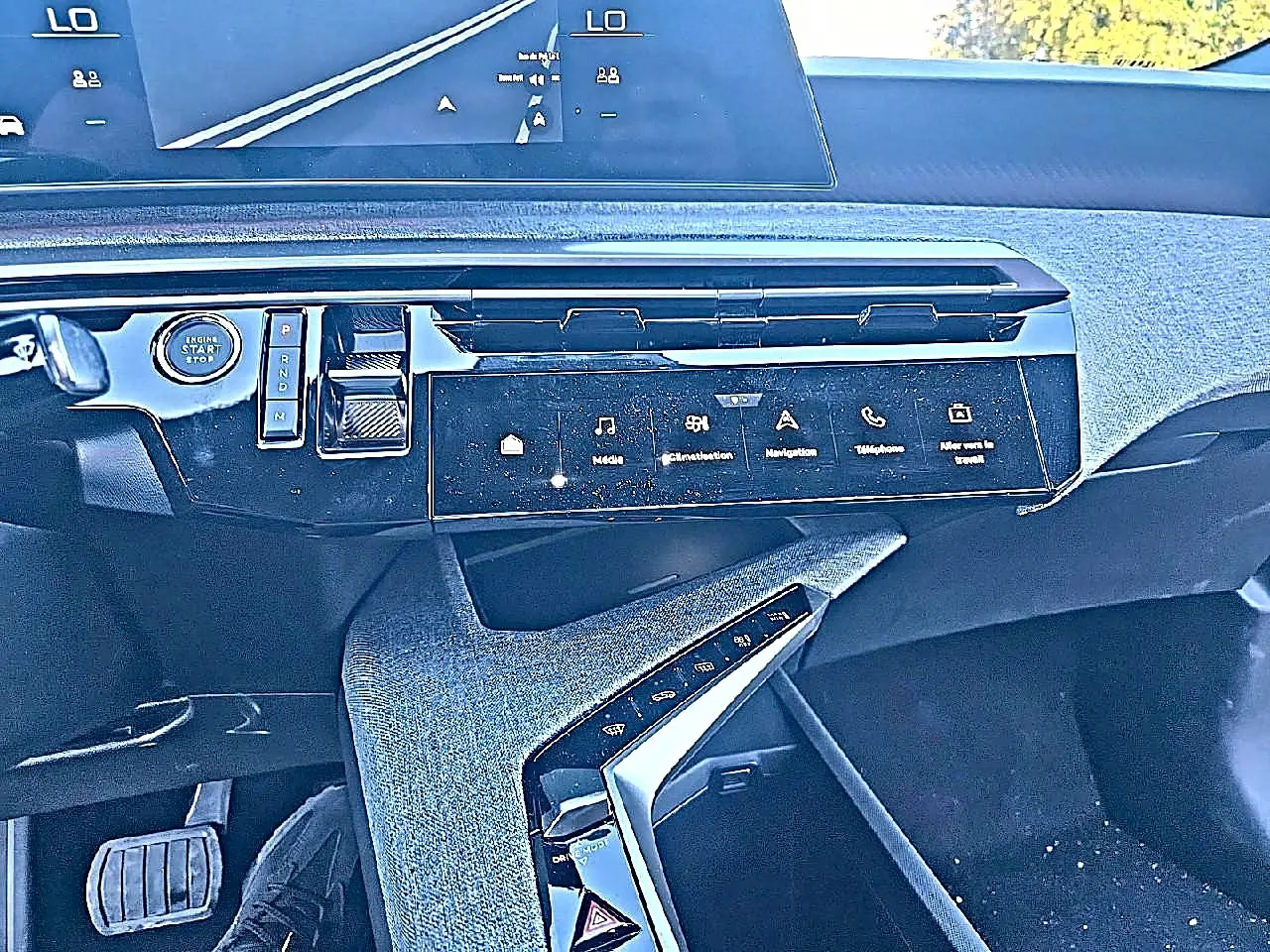 Vue intérieure du tableau de bord du Peugeot 5008 Hybrid blanc, avec écran tactile et commandes digitales intégrées.