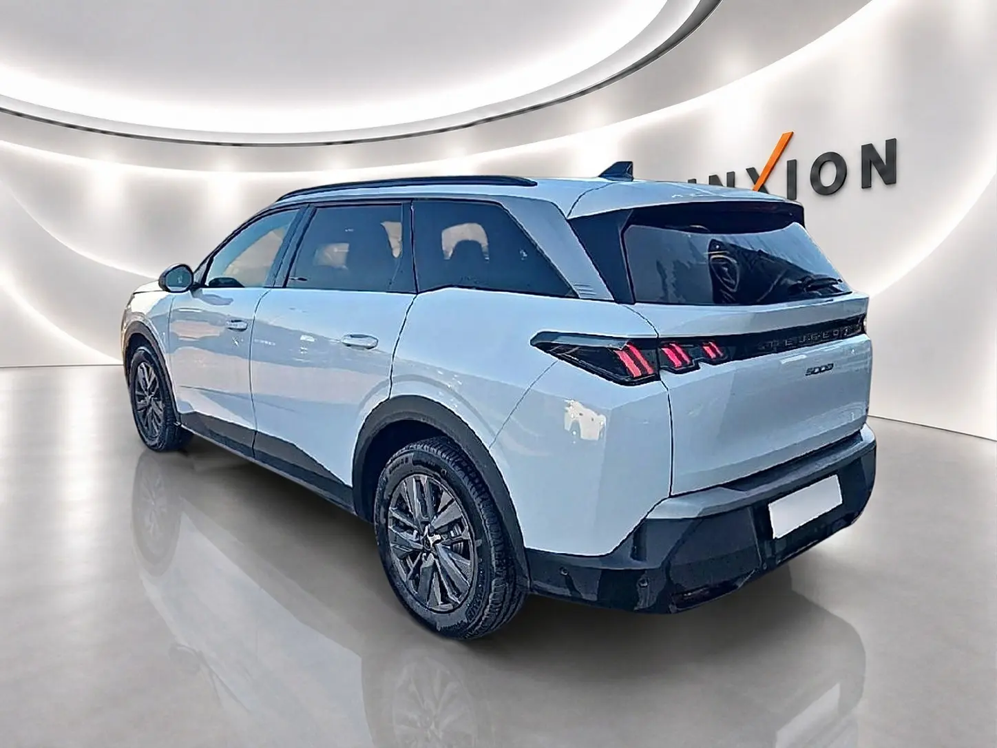 Peugeot 5008 blanc vue 3/4 arrière droit, avec feux arrière LED et jantes alliage foncé.