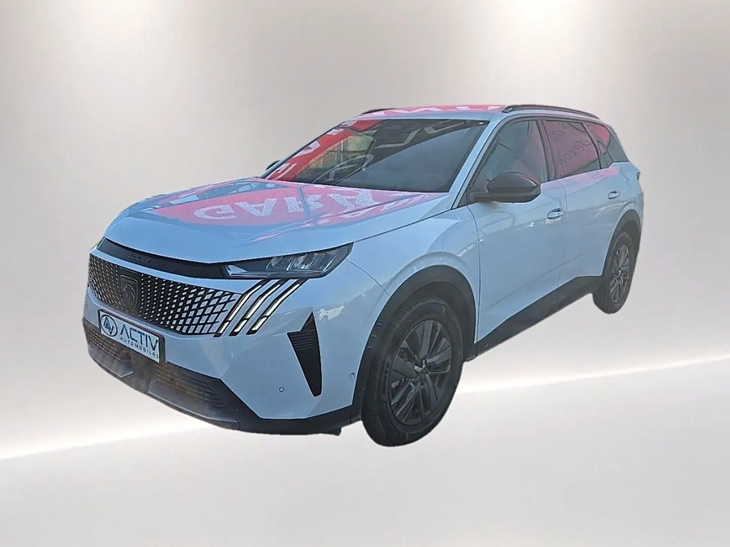 Peugeot 5008 blanc en 3/4 avant droit avec calandre distinctive à motifs et jantes alu noires.