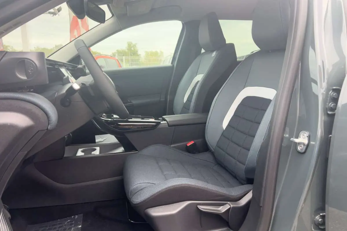 Vue intérieure côté conducteur du Citroën C5 Aircross Hybrid 145 Plus PK Drive 2026 avec sièges tissu gris et console centrale noire.